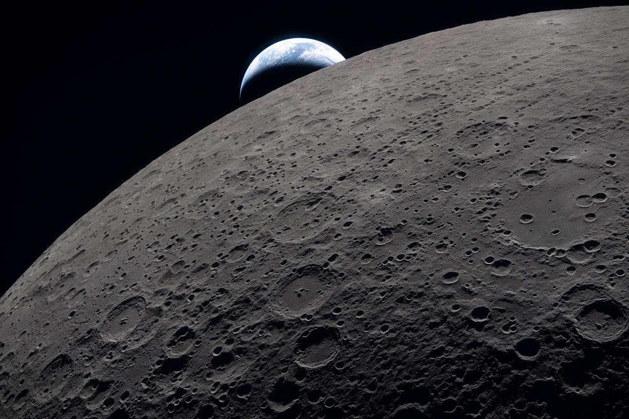 Cratered surface of the Moon with Earth in the distance